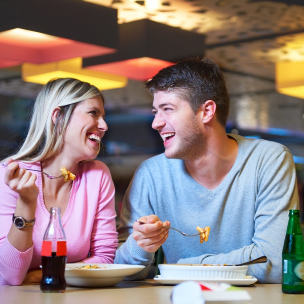photo of a young man and woman enjoying a meal together on what might be a date